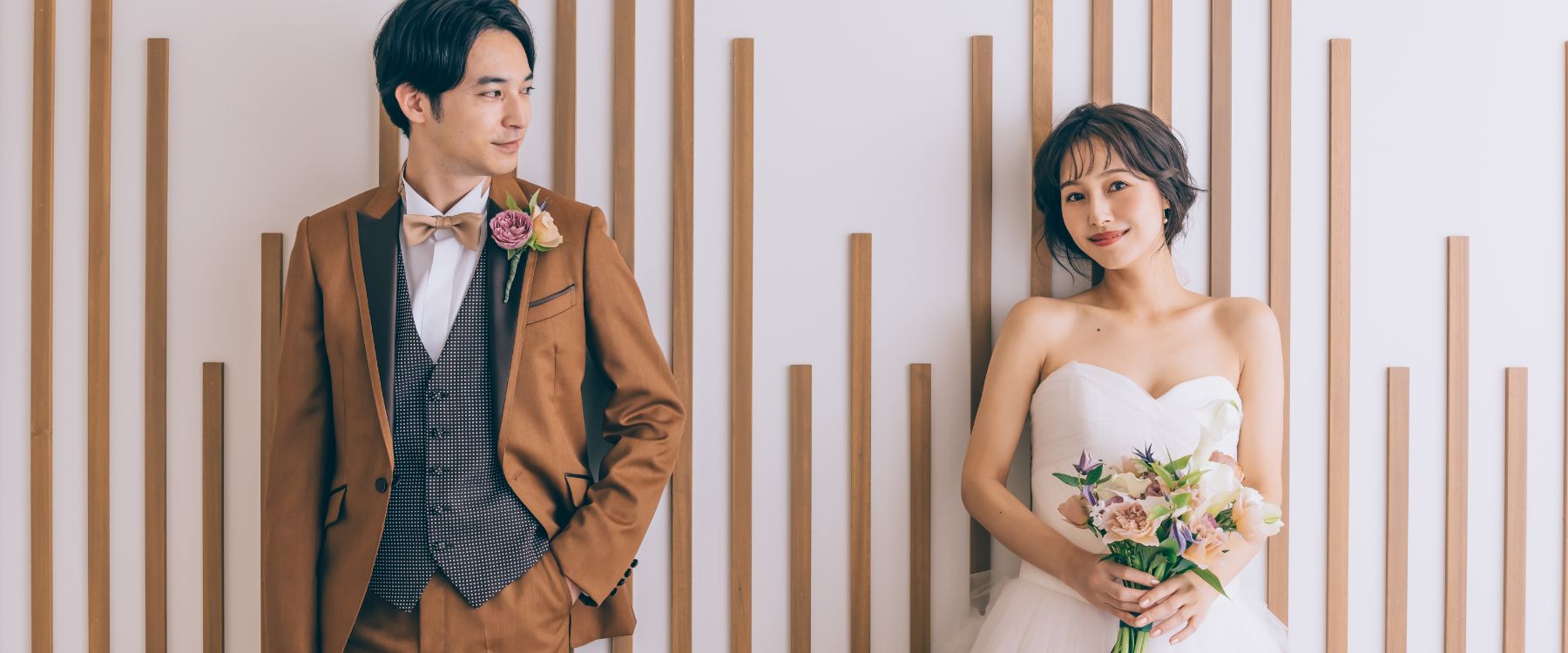 笑顔でブーケを持つ新婦様を見つめる新郎様のウェディングフォト