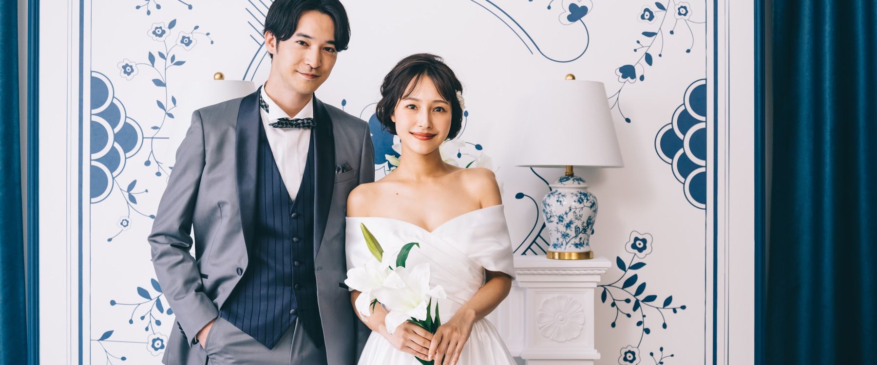 百合の花を持って微笑む新婦様と新郎様の結婚写真
