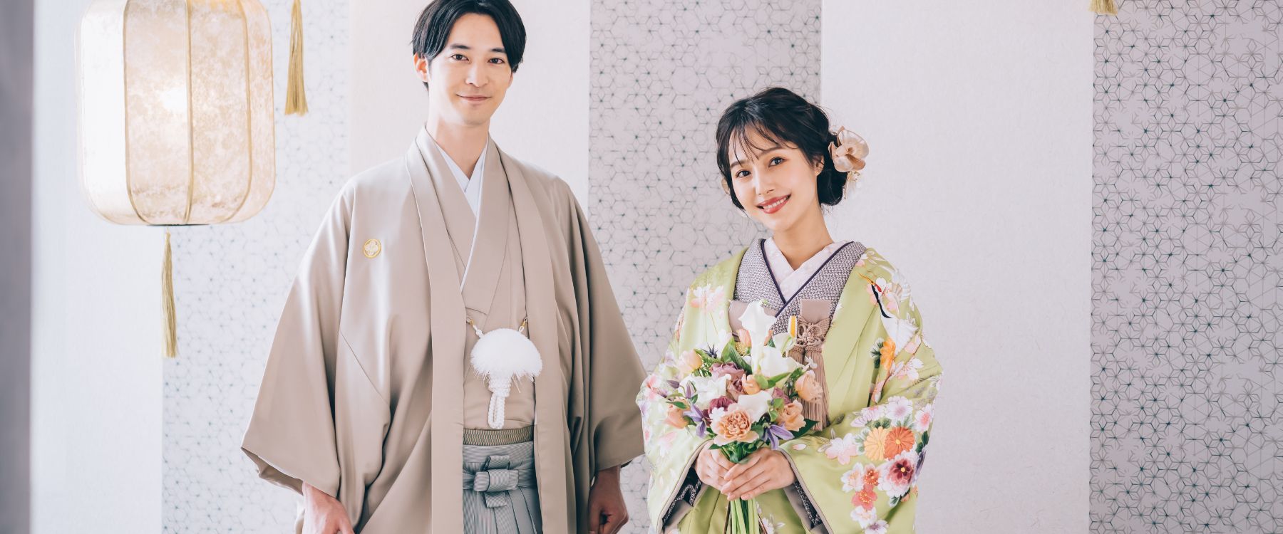 モダンな壁とランタンを背景に微笑む新郎新婦様のスタジオ撮影