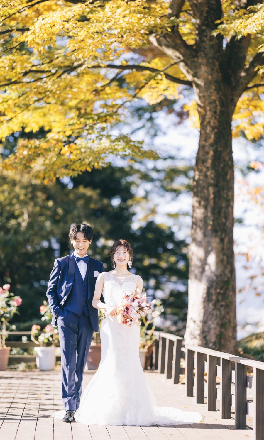 ブーケを持って微笑む新婦様と新郎様のウェディングフォト