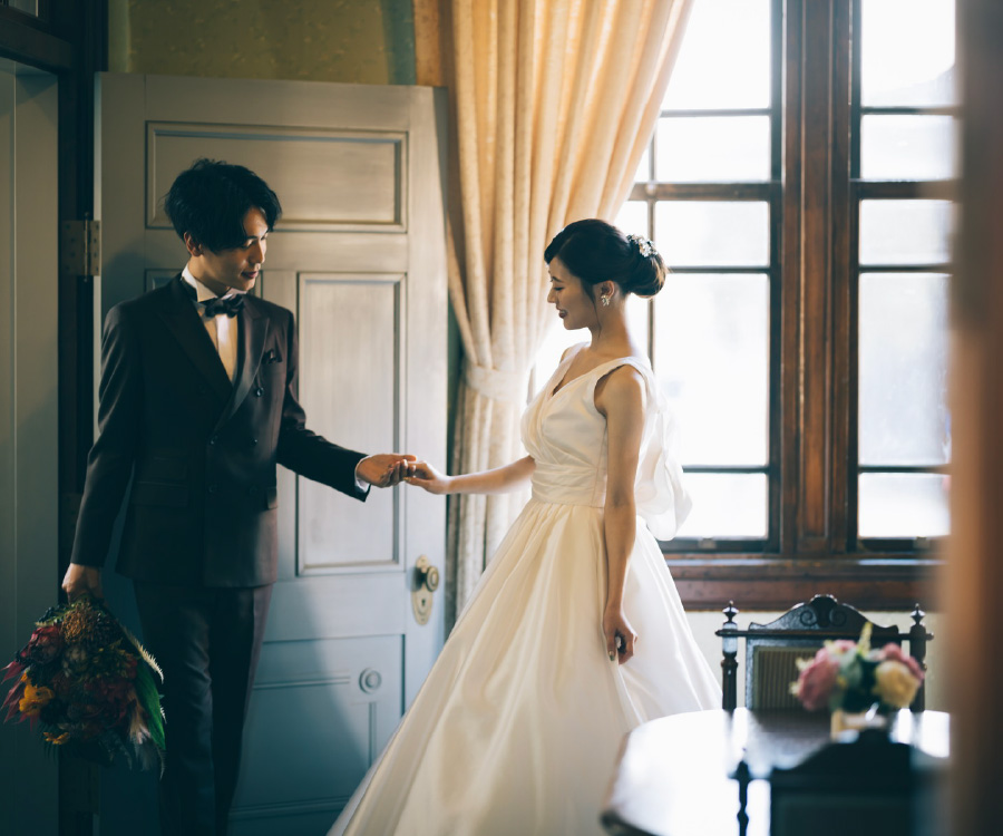 新婦様の手を取る花束を持った新郎様のウェディングフォト