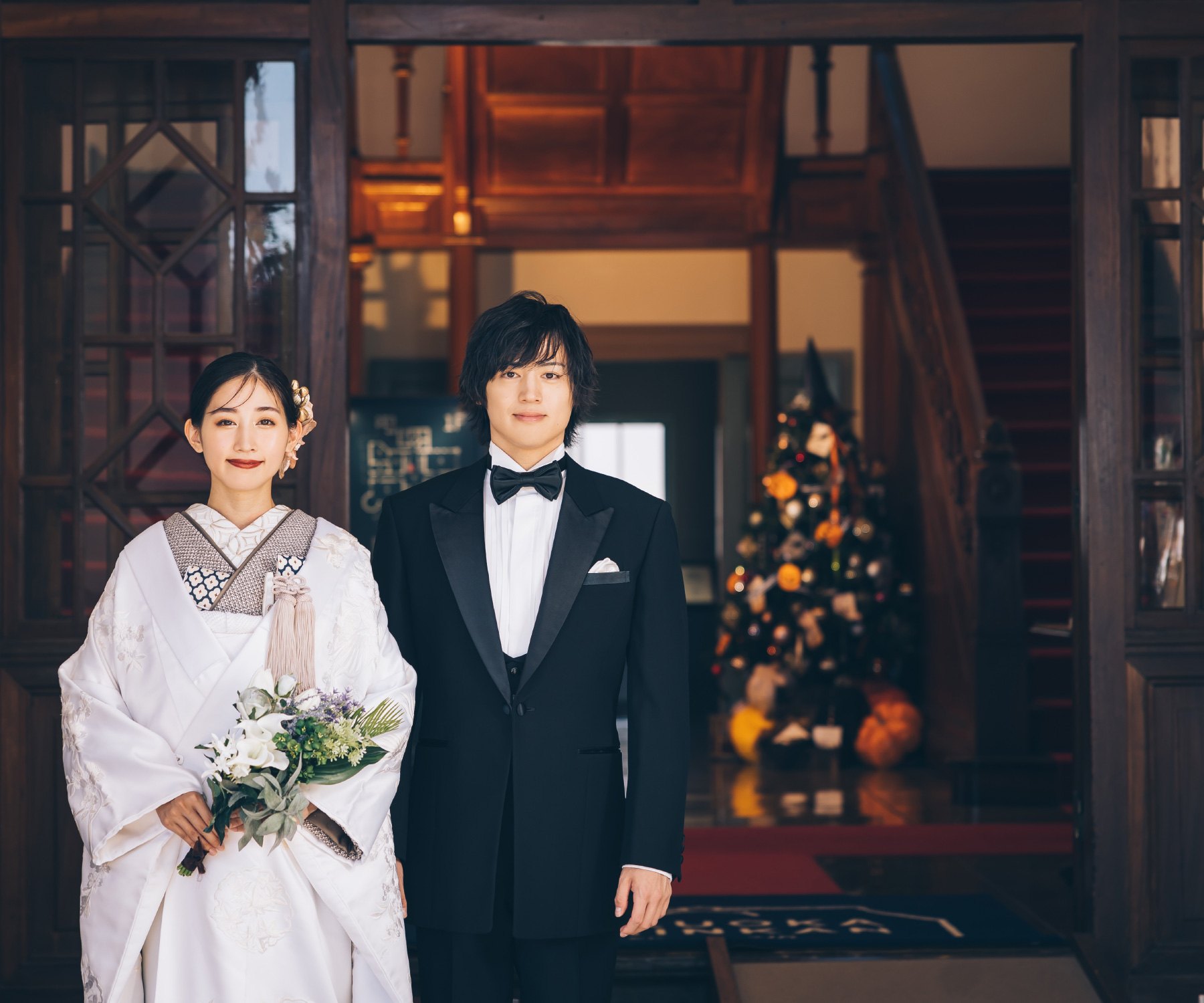 貴賓館を背景に花束を持った新婦様と新郎様のロケーションフォト