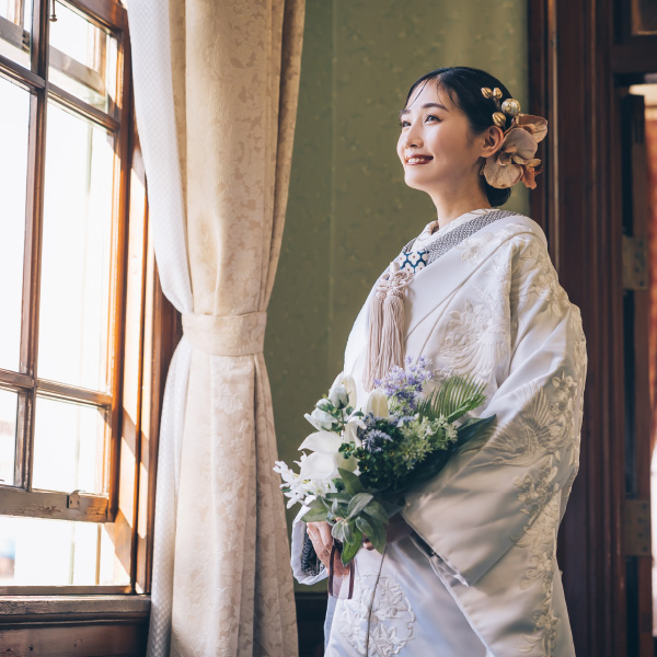 花束を持った新郎様に体を預ける新婦様のウェディングフォト