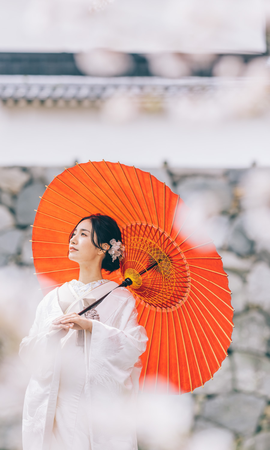 赤い和傘をさして空を眺める新婦様のソロショット