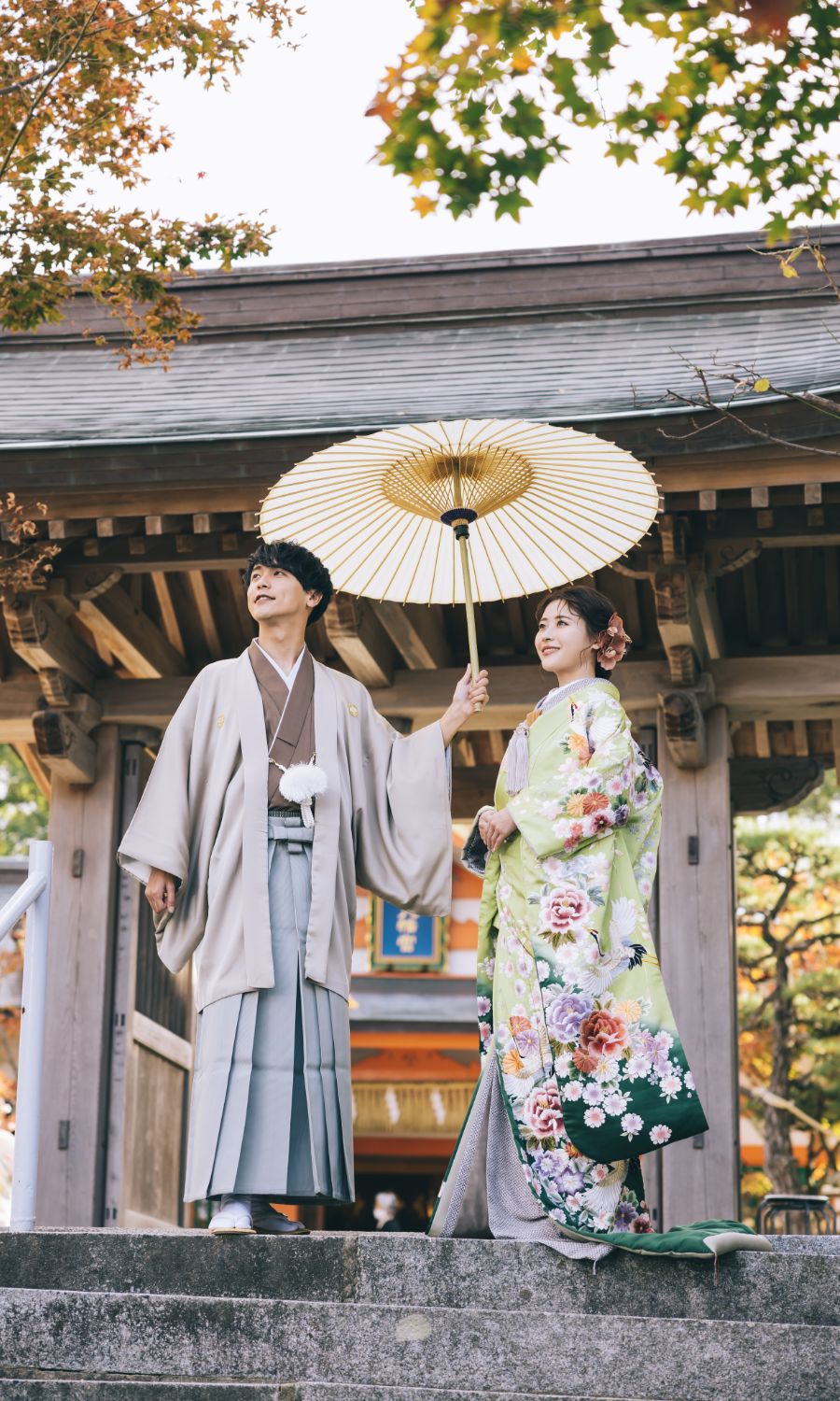 立派な鳥居の下で白い和傘をさす新郎様と新婦様の和装前撮り