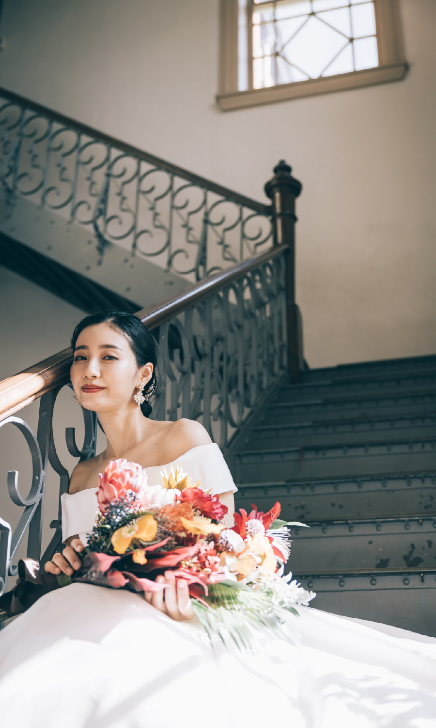 ブーケを持って微笑む新婦様と新郎様のウェディングフォト