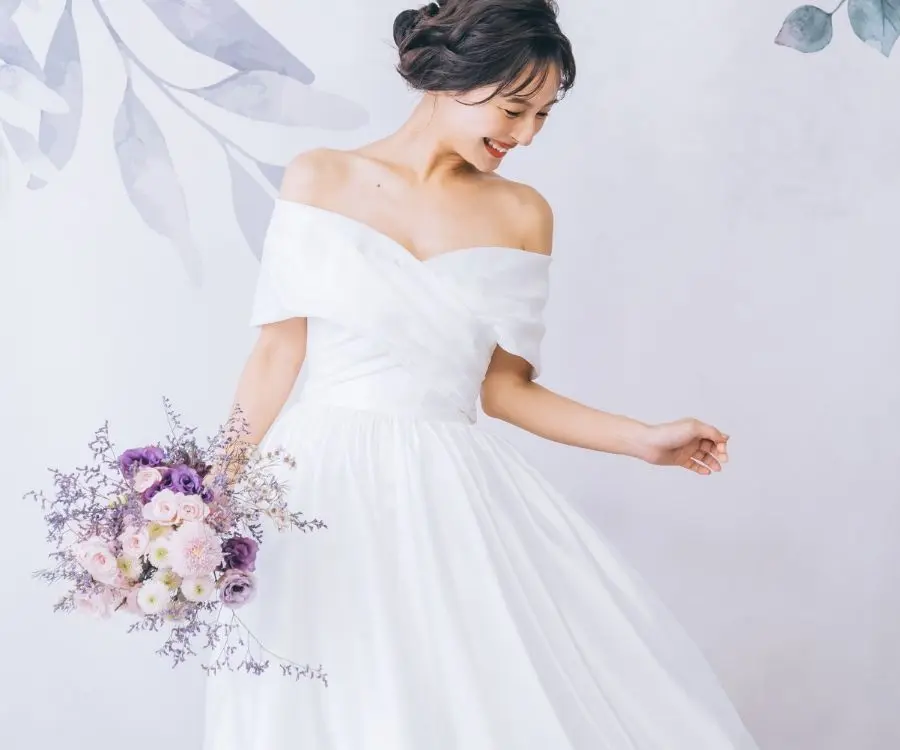                満面の笑みでブーケを持つ新婦様の洋装ソロショット     