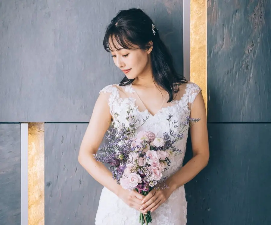                ブーケを抱えて目を伏せる新婦様のウェディングフォト     