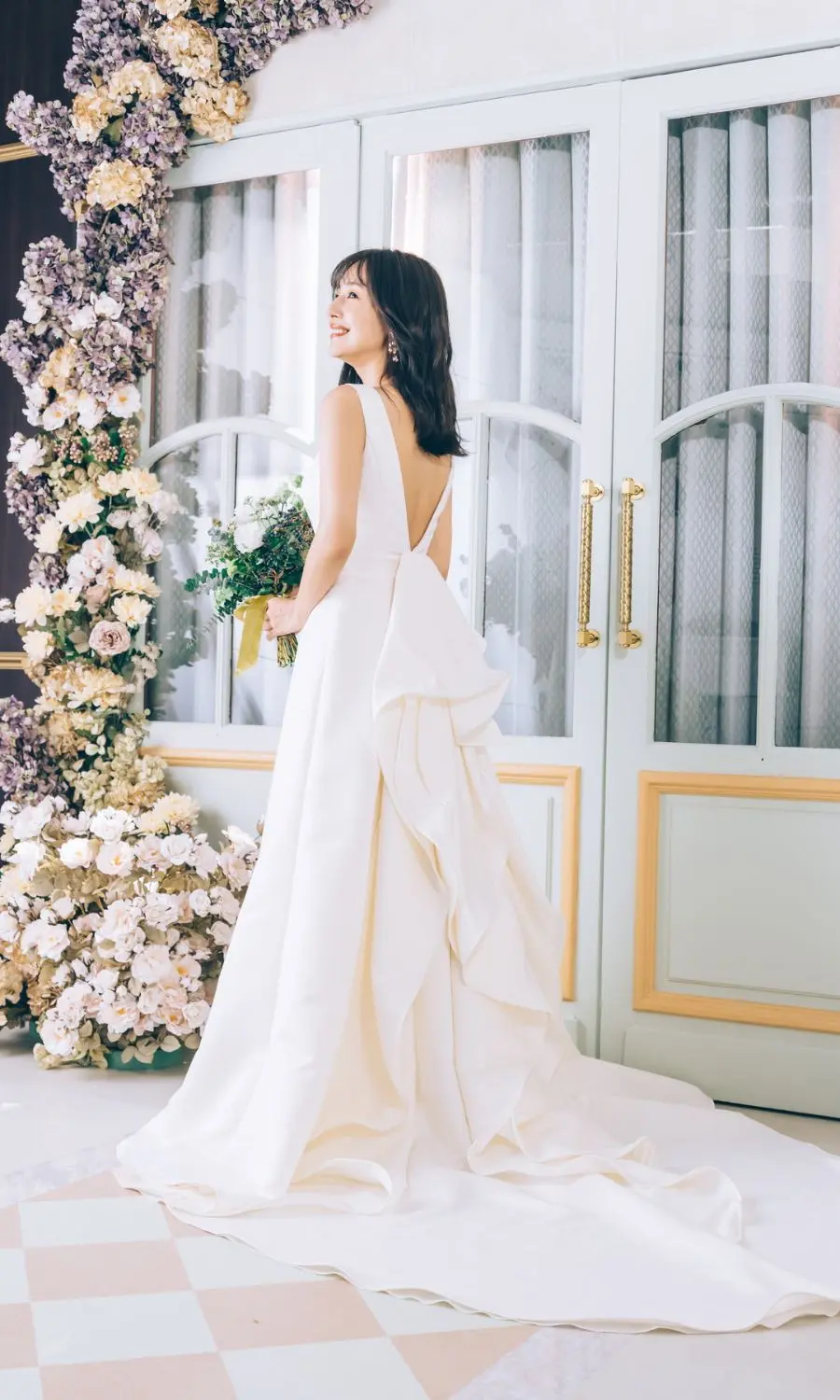                花束を抱えて笑う新婦様のバックショット     