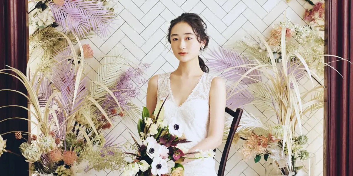 バックのドライフラワーが映える、椅子に座った新婦様