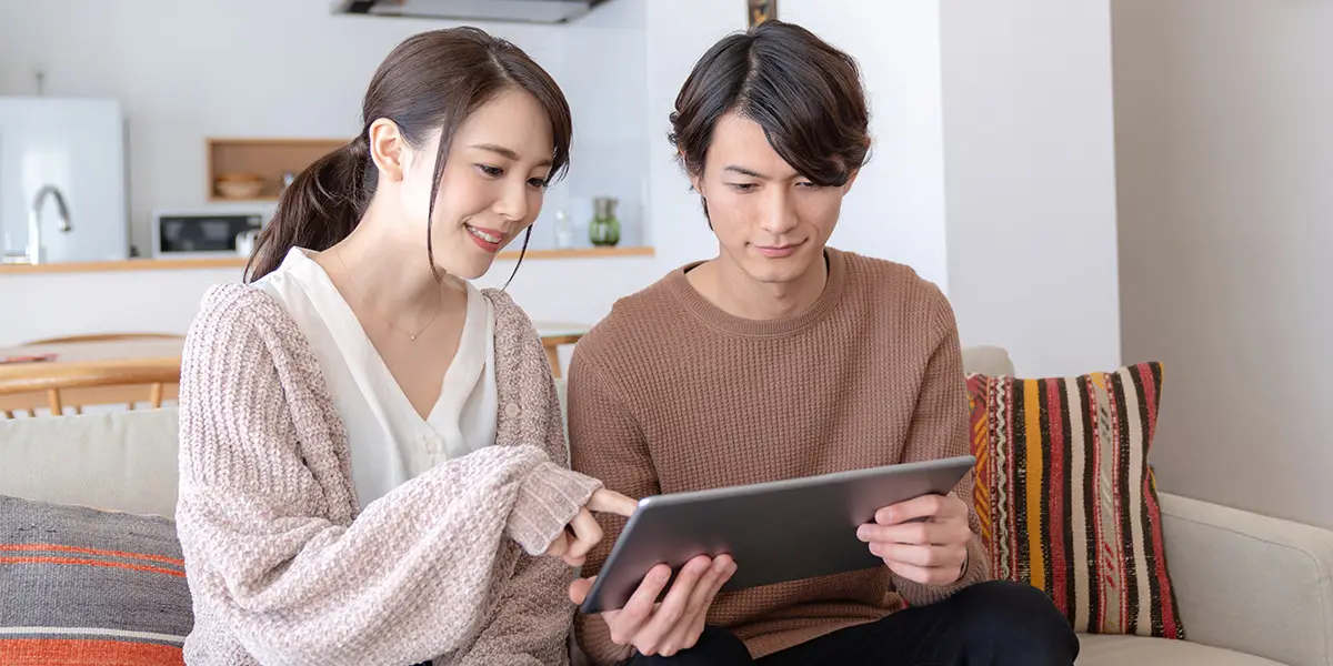 タブレットで見学予約をするカップルの様子