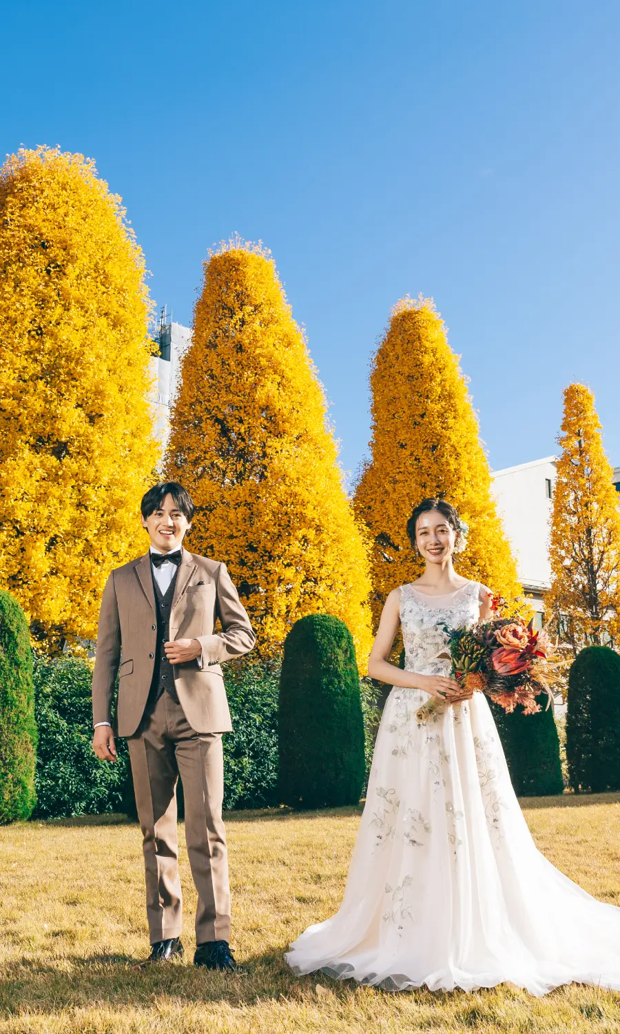 鮮やかな緑の中、背中をくっつけて笑う新郎新婦様のウェディングフォト