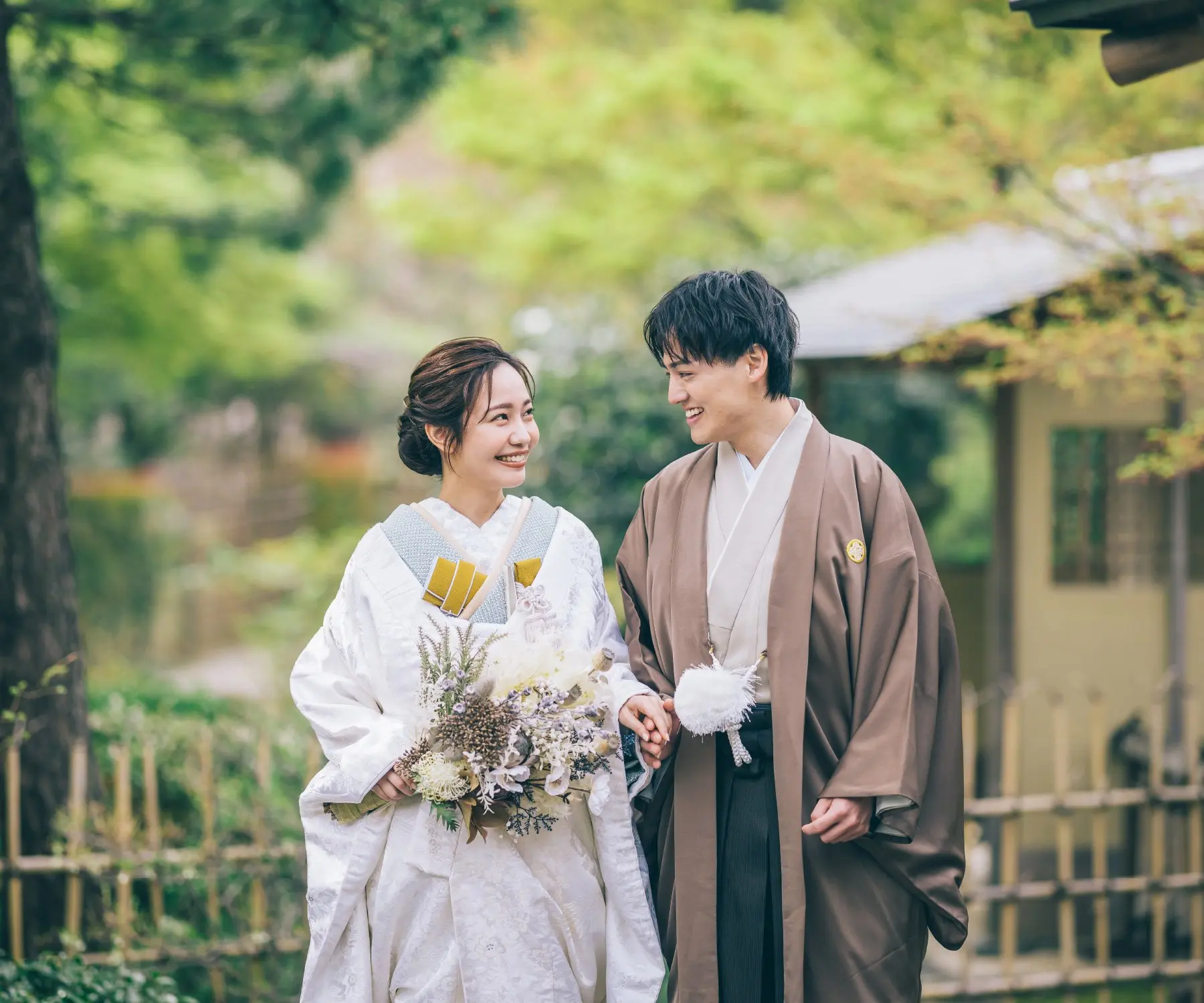 並木道の真ん中で笑顔で背中を合わせる新郎新婦様のロケーションフォト