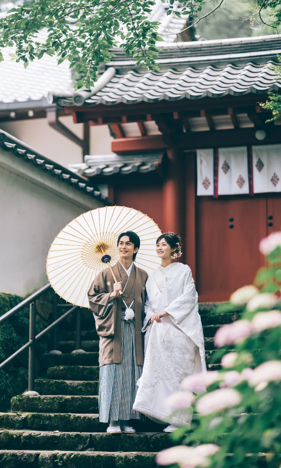 鮮やかな緑の中、背中をくっつけて笑う新郎新婦様のウェディングフォト