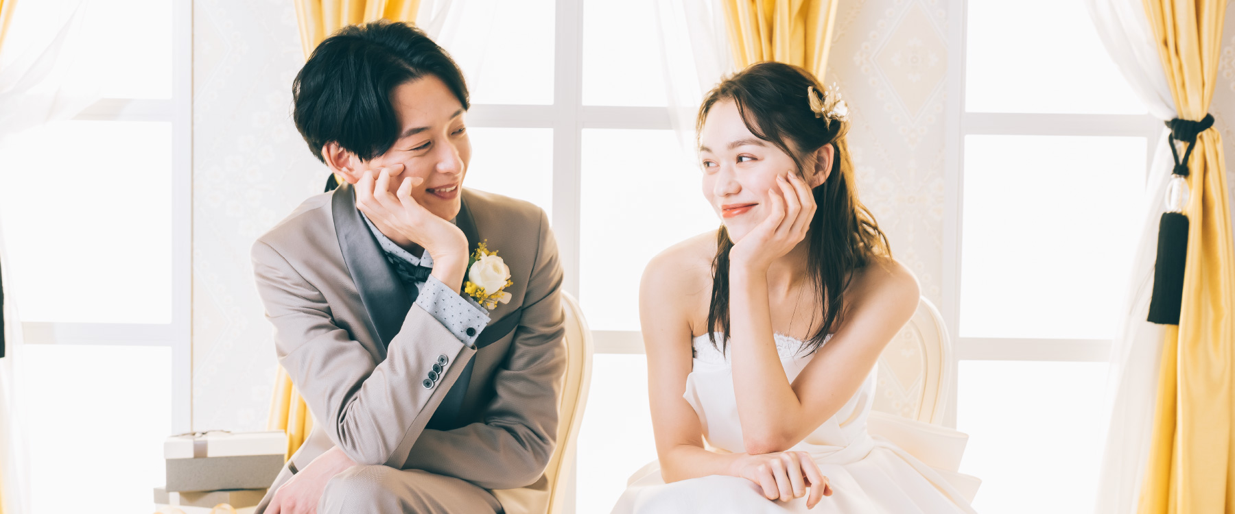 頬杖をついて見つめ合う新郎新婦様のウェディングフォト