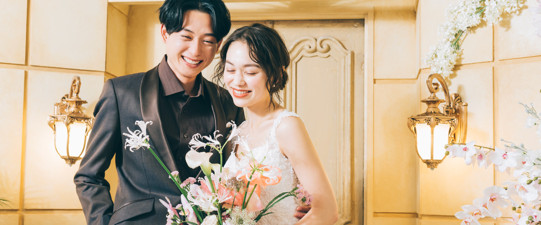 ブーケを抱えて微笑む新婦様と新郎様のウェディングフォト