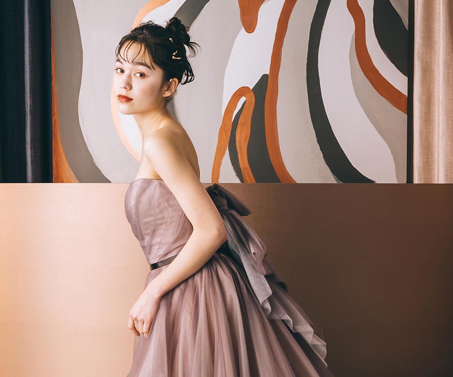                     テラコッタのカラードレスを着てアンニュイな表情をする新婦様のソロショット