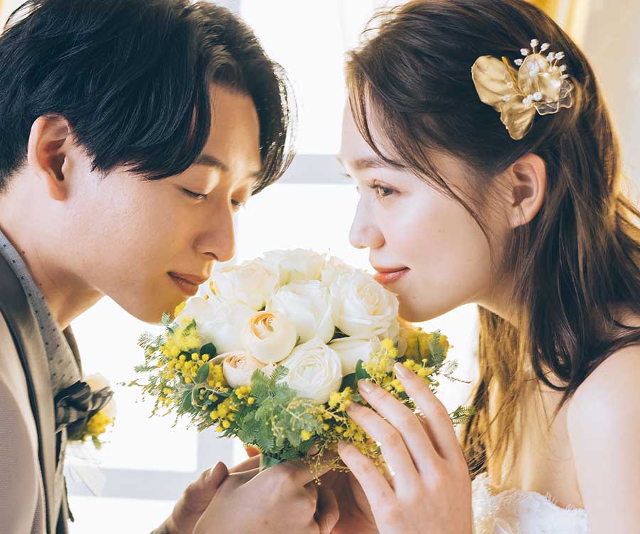                     花束越しに向かい合う新郎新婦様のアップショット