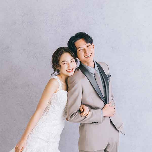                     腕を組んで楽しそうに笑う新郎新婦様のウェディングフォト
