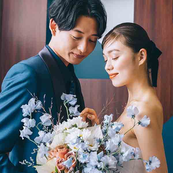                     向かい合ってブーケを見つめる新郎新婦様のウェディングフォト