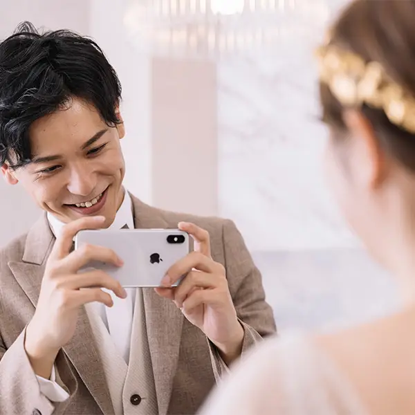 スマホで新婦様を撮影する新郎様