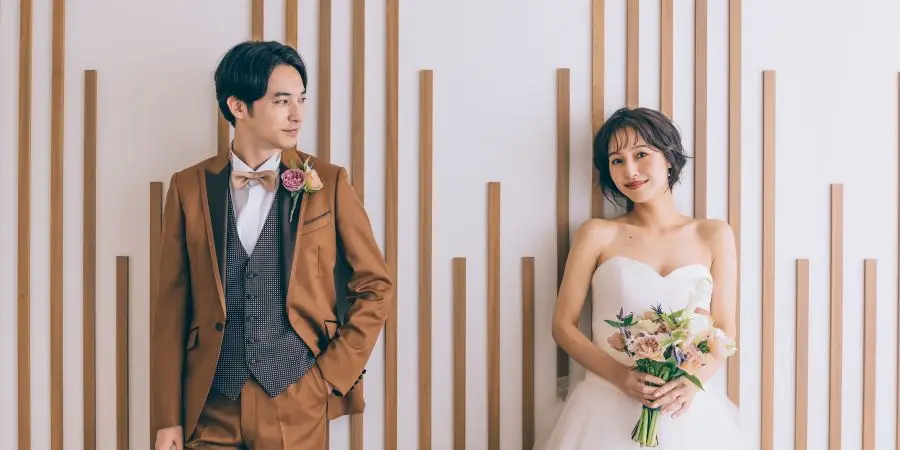 笑顔でブーケを眺める新婦様のウェディングフォト