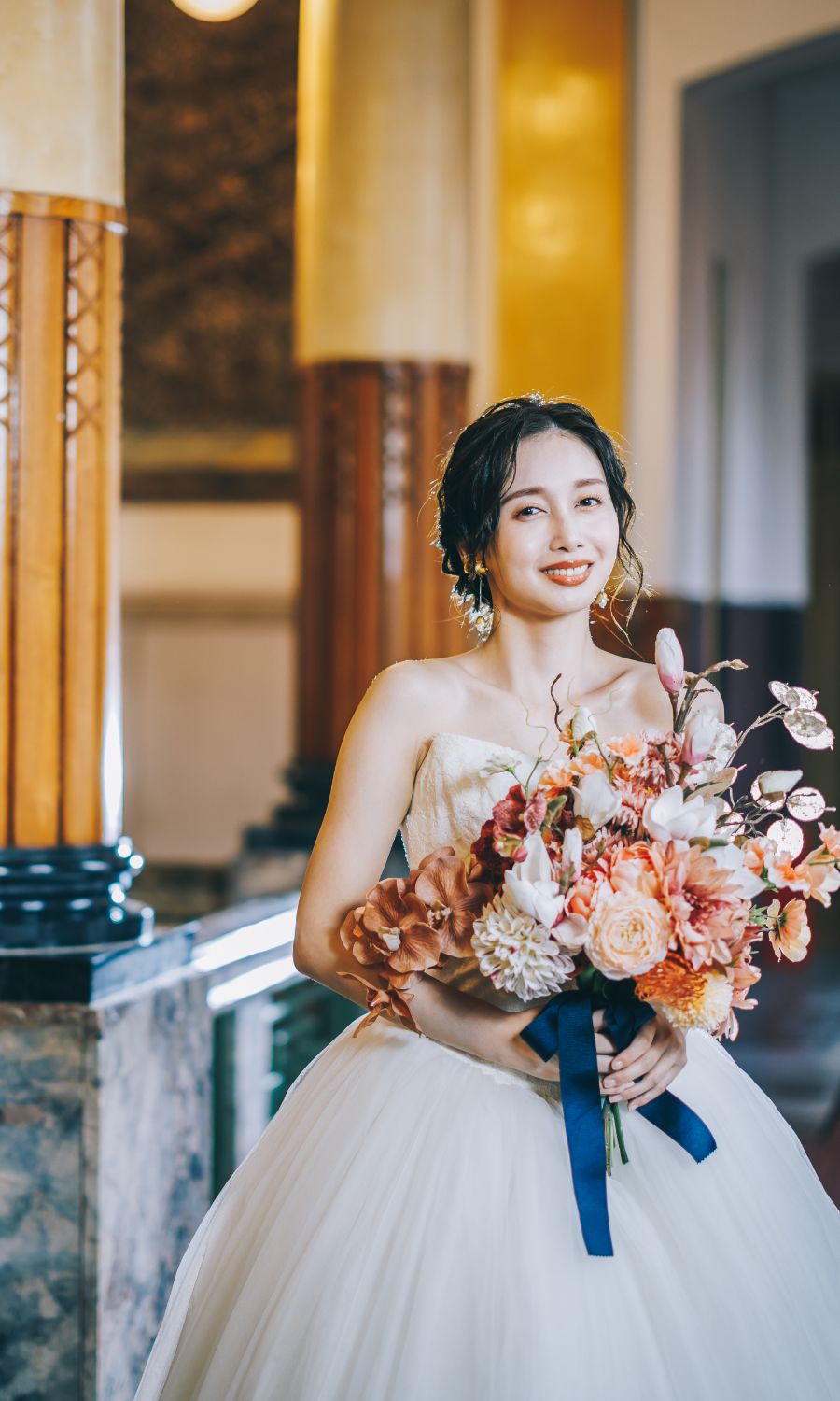 花束を抱えて優しく微笑む新婦様のソロショット