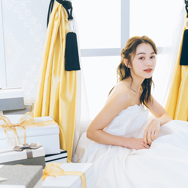                     窓からこぼれる光に映えるウェディングドレスを着た新婦様のソロショット