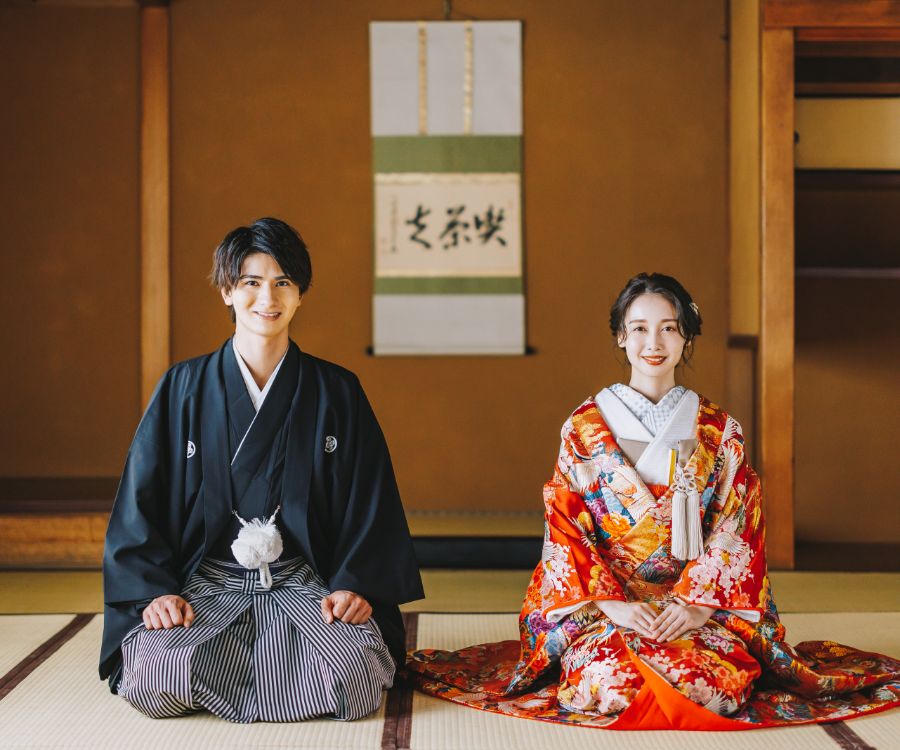 和室で正座をして微笑む新郎新婦様の和装前撮り
