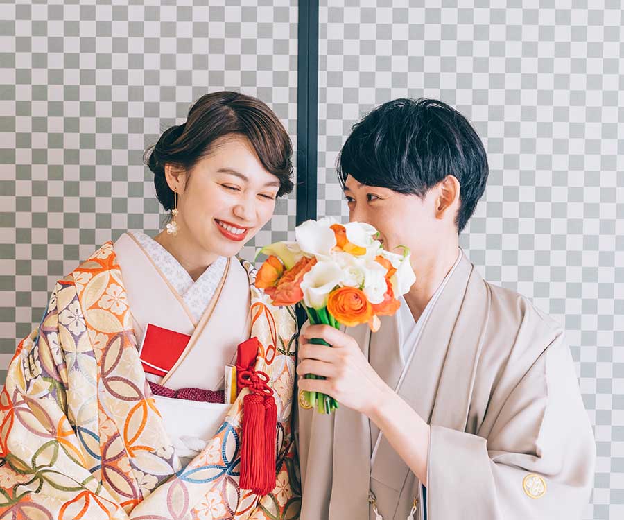                     花束で口元をかくして話す新郎様と笑う新婦様の和装前撮り