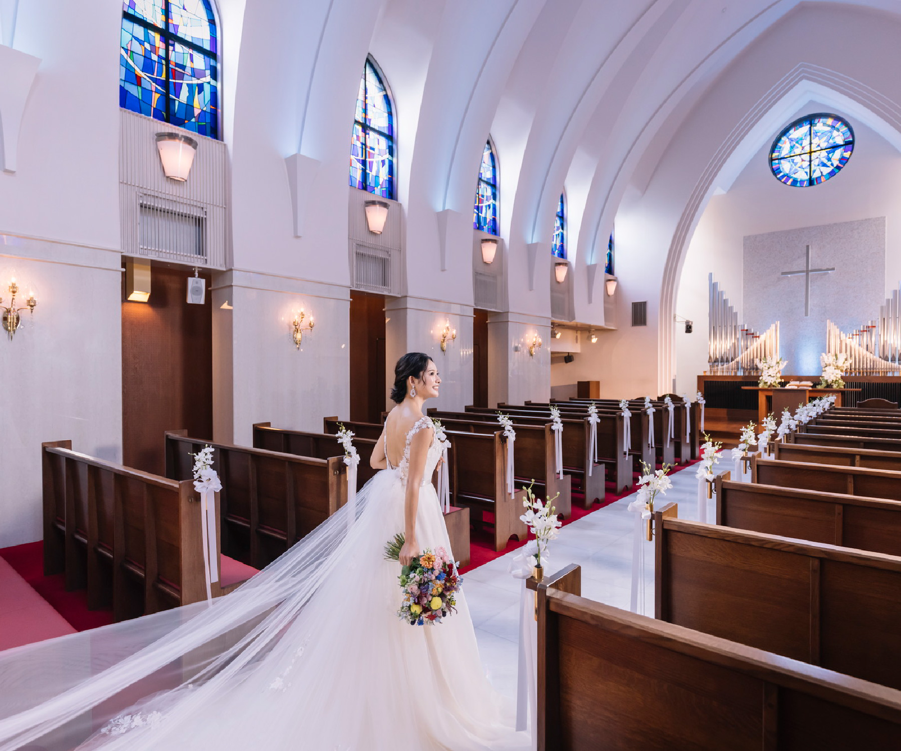 ブーケを持って笑顔でヴァージンロードを歩く新婦様のソロショット