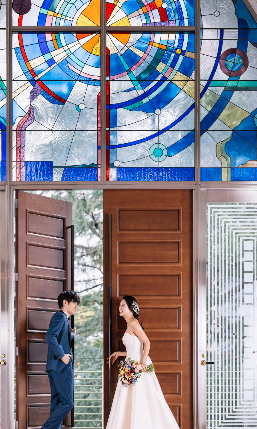 新婦様のために扉を開ける新郎様の結婚写真