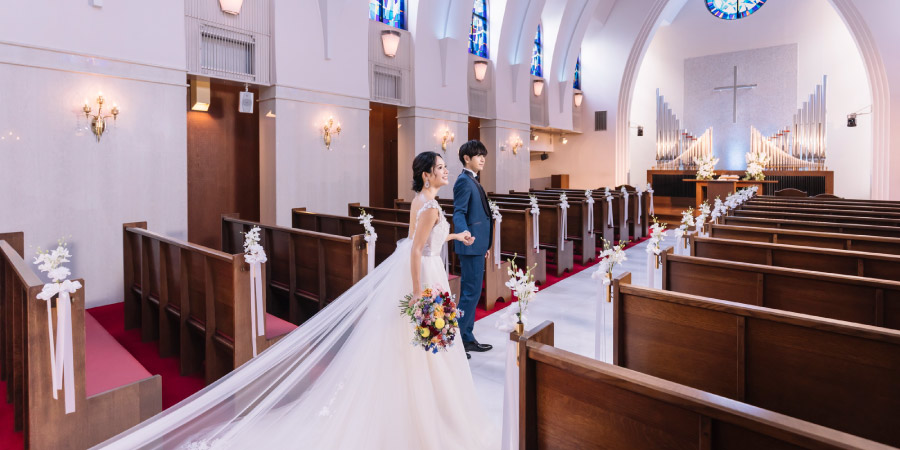 ヴァージンロードで新婦様の手を取る新郎様