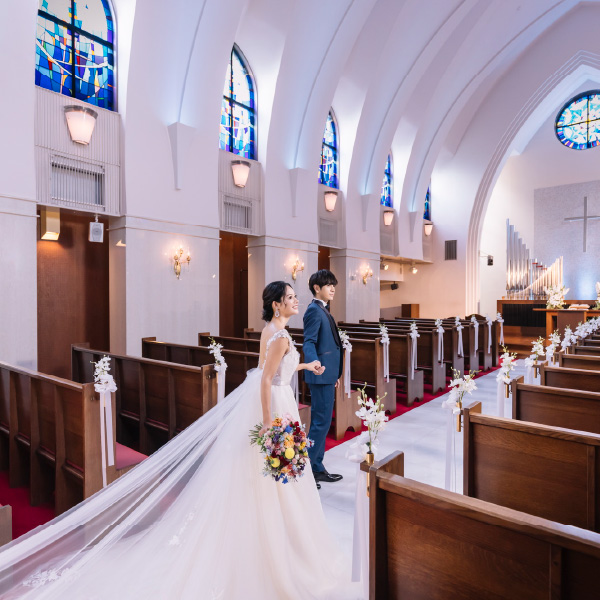 ヴァージンロードで新婦様の手を取る新郎様のウェディングフォト