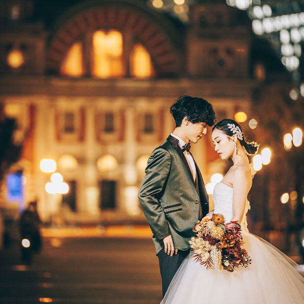 煌びやかな中央公会堂をバックにポーズをとる新郎新婦様のナイトロケーションフォト