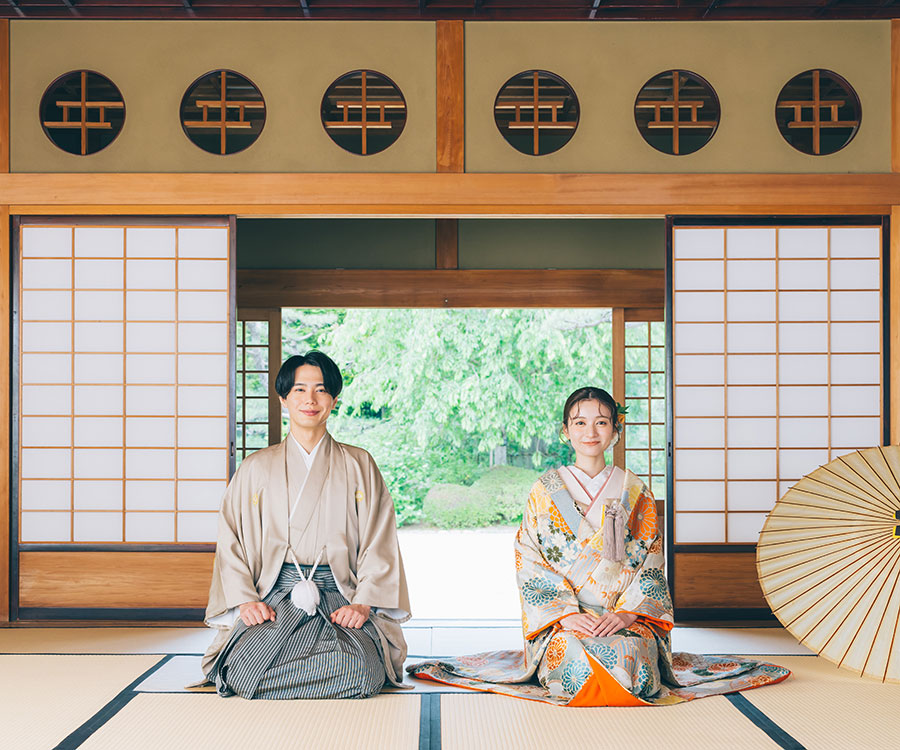伝統的な日本家屋の前で佇む新郎新婦様の結婚写真
