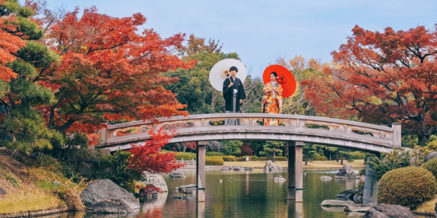 橋の上で和傘をさす新郎新婦様のロングショット