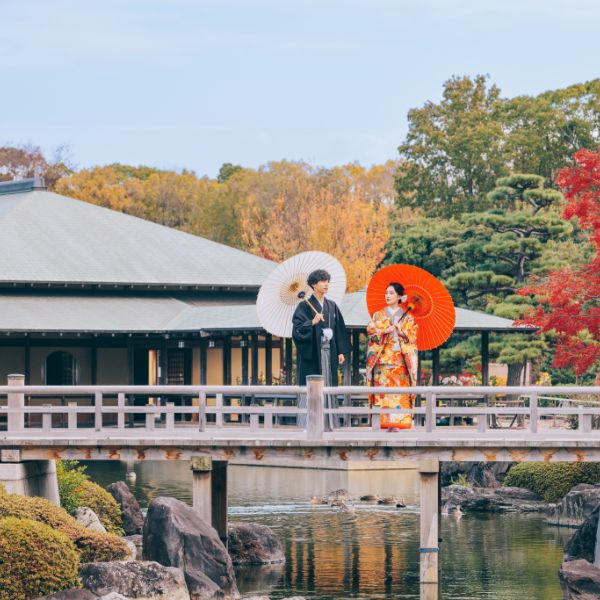 東屋をバックに欄干でお互いを見つめる新郎新婦様のロケーションフォト