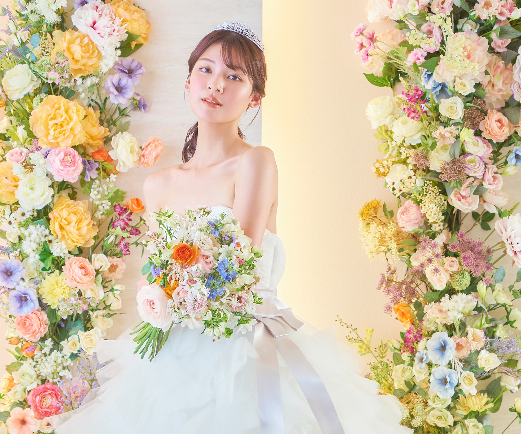           色彩豊かな花々に囲まれながらブーケを持つ新婦様のソロショット          