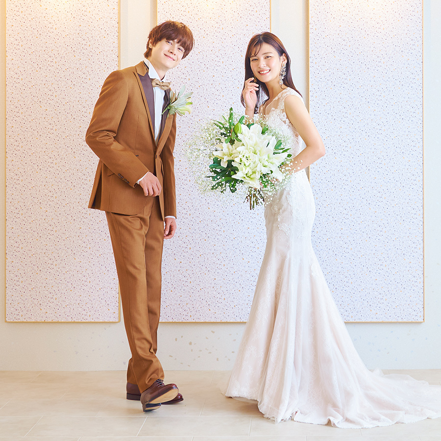 楽しそうに微笑みながらこちらを見つめる新郎新婦様のウェディングフォト