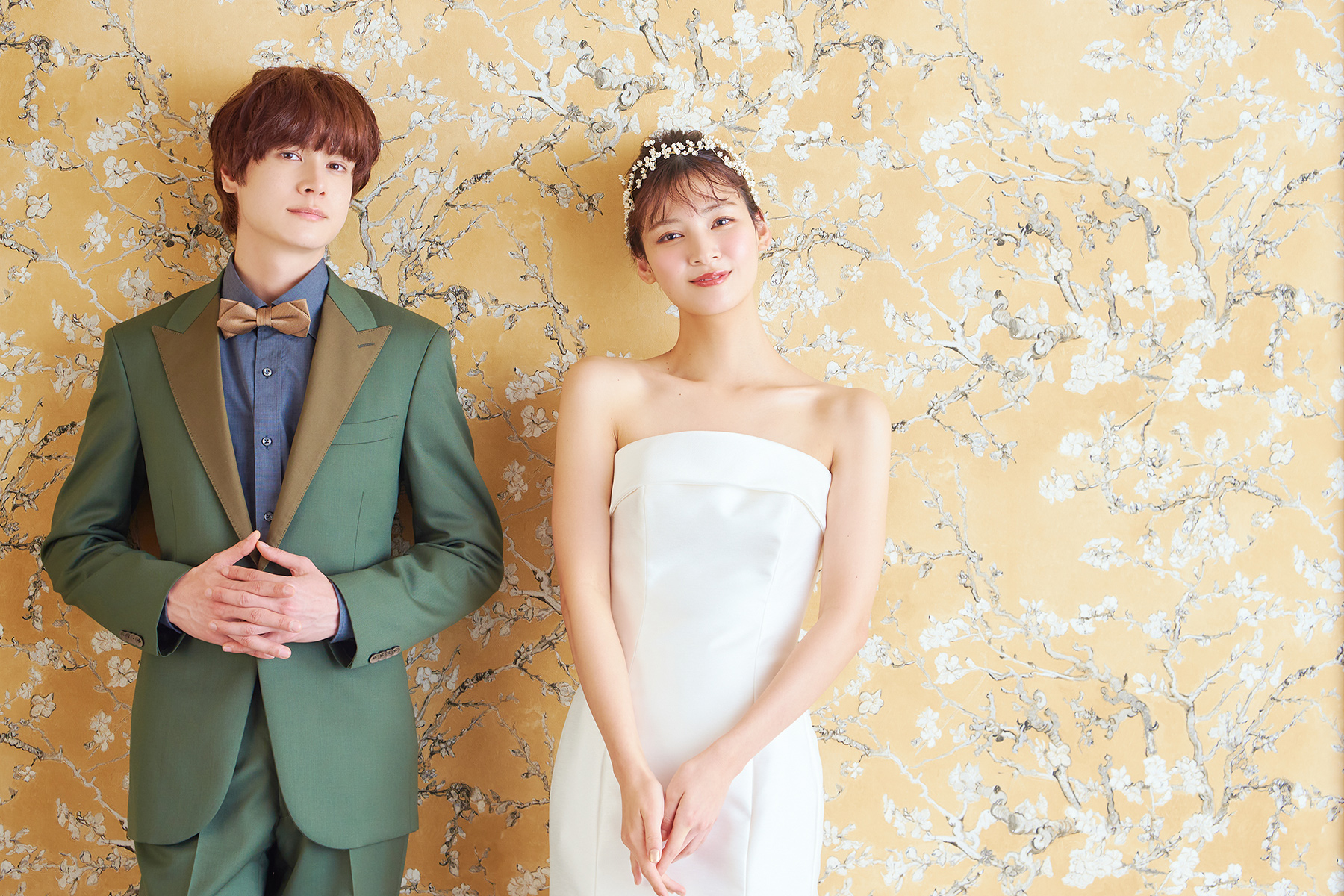 ラグジュアリーな壁紙の前で微笑む新郎新婦様