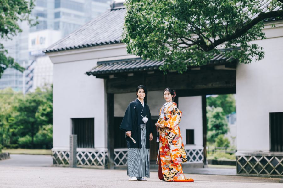 慶沢園の門の前で微笑む新郎新婦様の結婚写真