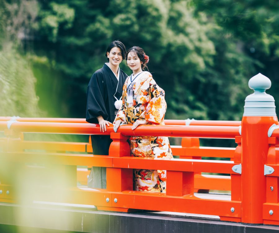 欄干に寄り掛かって微笑む新郎新婦様の結婚写真