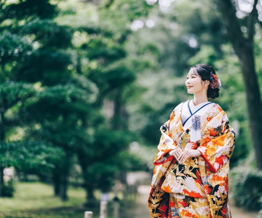 新緑の中、微笑みながら遠くの景色を眺める新婦様のソロショット