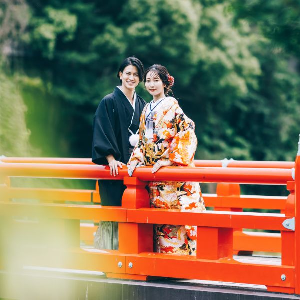 欄干に寄り掛かって微笑む新郎新婦様の結婚写真