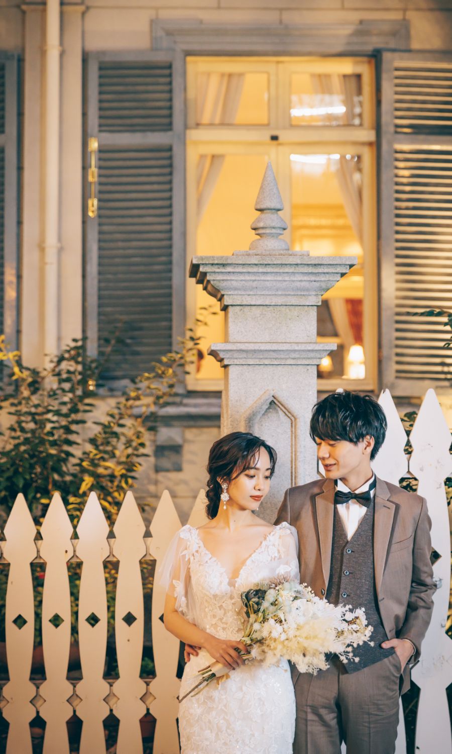 ブーケを持った新婦様を優しく見つめる新郎様の結婚写真