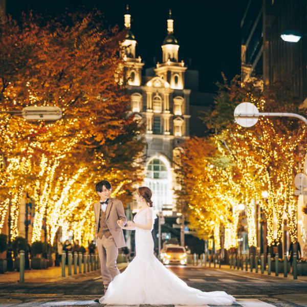 イルミネーションをバックにエスコートをする新郎新婦様