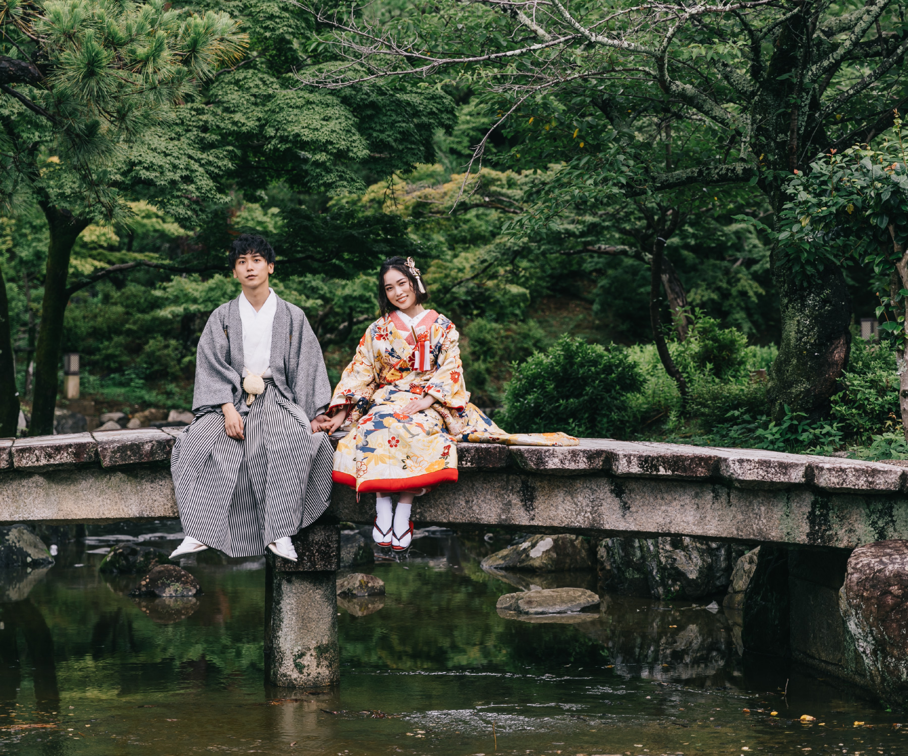 池の上の石橋で休憩する新郎新婦様のロケーションフォト