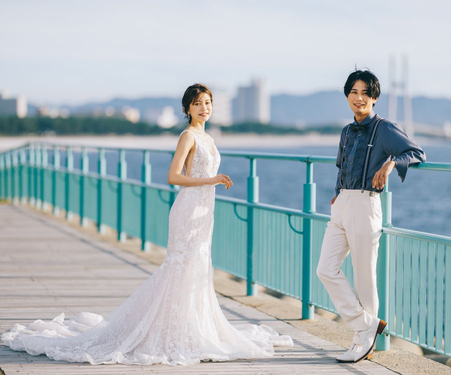 海をバックにこちらを見る新郎新婦様