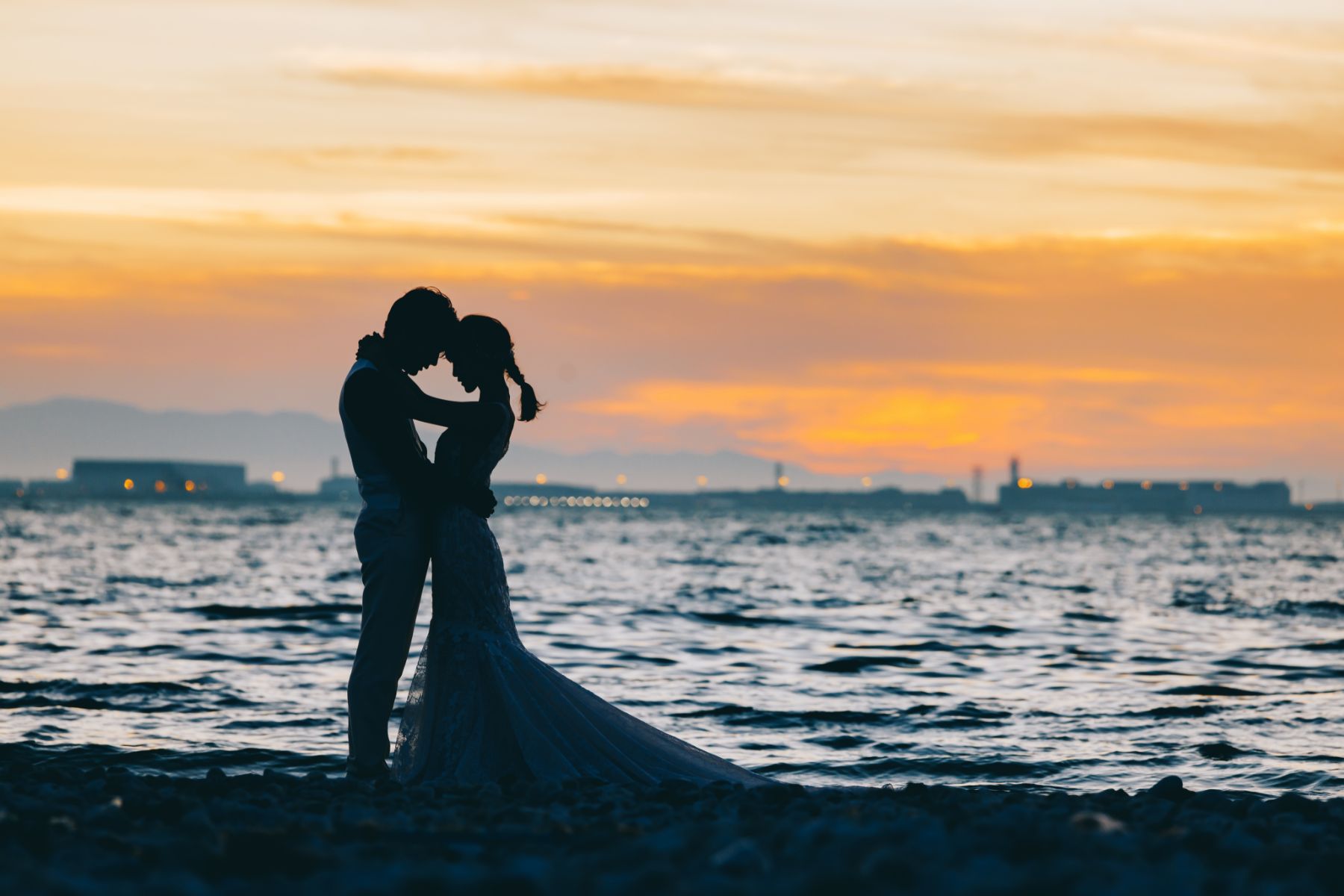 夕景が美しい浜辺で誓い合う新郎新婦様のシルエットショット